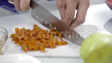 <strong>双手</strong>用大刀在砧板上切碎干燥的杏。 烹饪健康<strong>食品</strong>